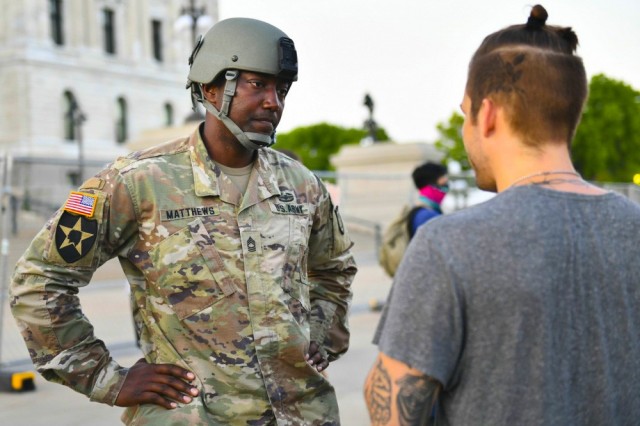 Image: Minnesota National Guard Master Sgt. Acie Matthews Jr. peacefully engages with protesters to show solidarity and request compliance with the state curfew at the grounds of the Minnesota state capitol in St. Paul, June 1, 2020. The Minnesota Guard has activated troops to protect citizens and infrastructure as people protested on the steps of the capitol building. (Photo Credit: Sgt. Linsey Williams)