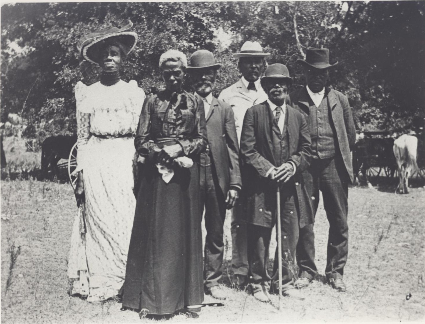 Black family dressed up standing together outside. 